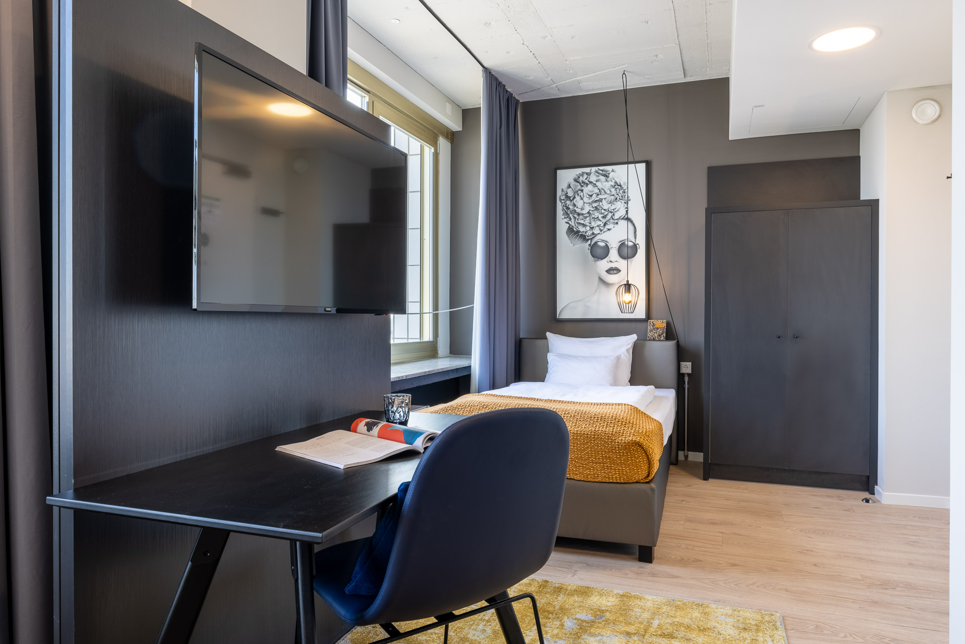 View of the open-plan living and sleeping area with a single bed in the Apartment Smart Single for temporary living in Cologne