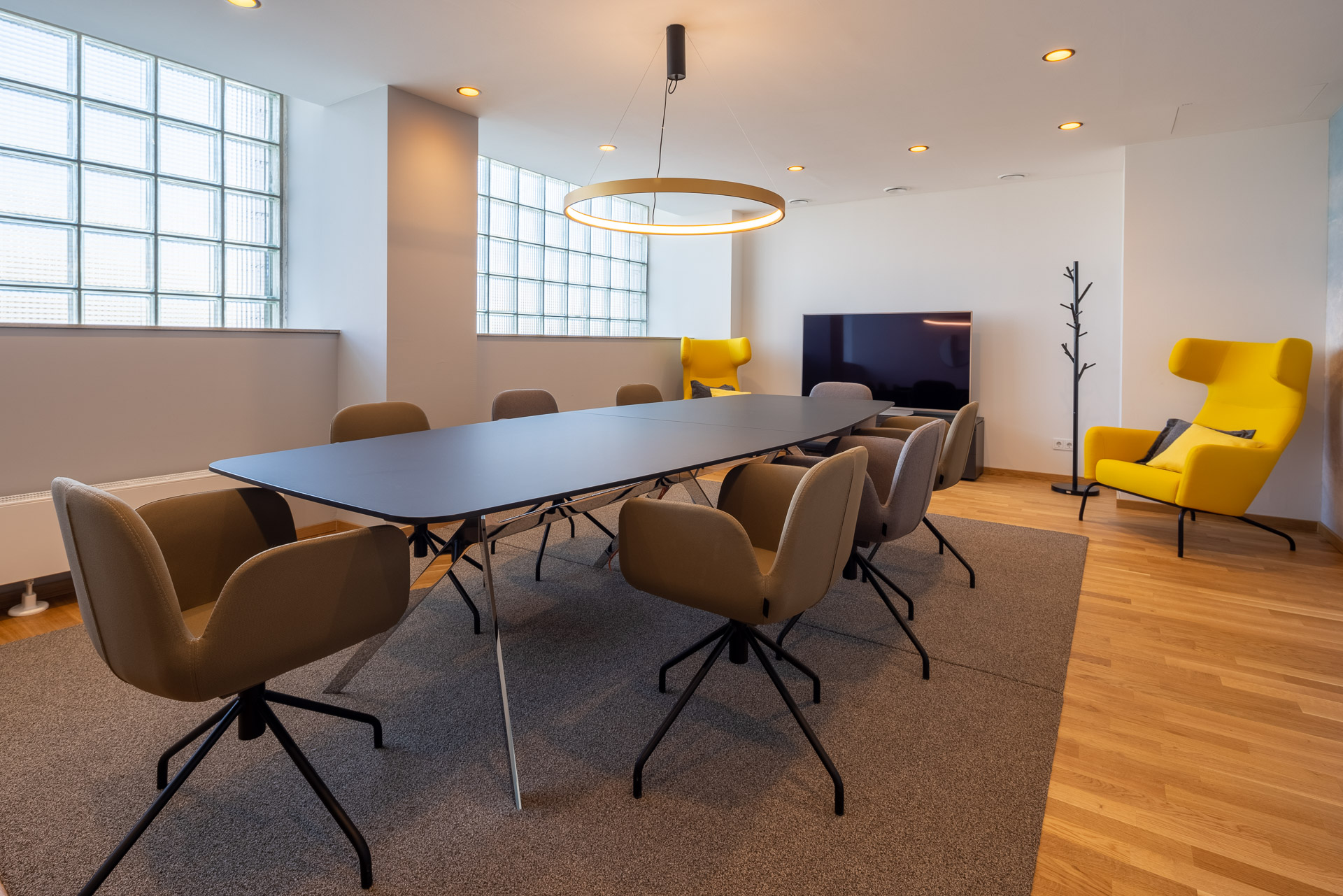 Insight into a modernly designed meeting room with a large table and comfortable seating at JOYN Cologne.