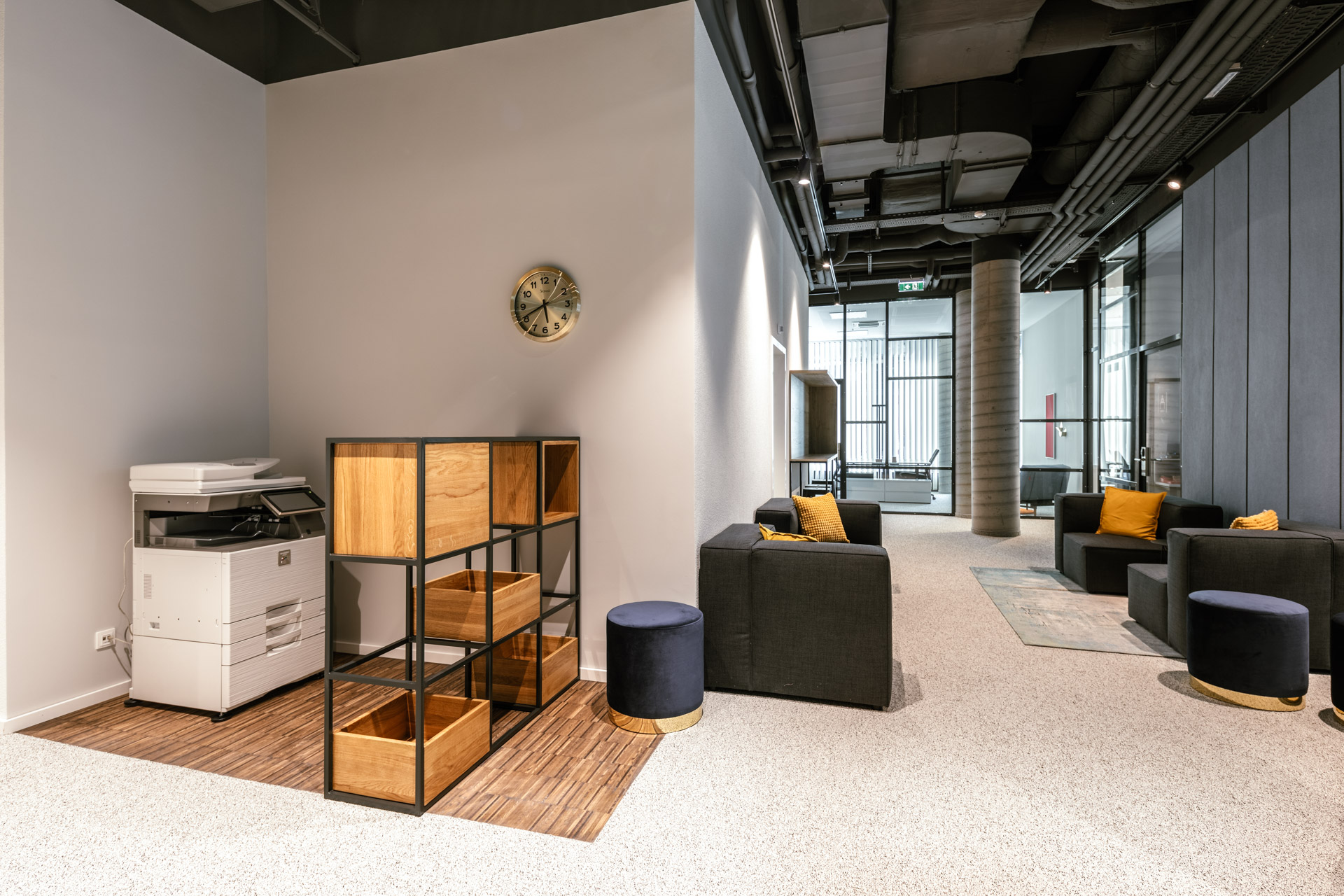 Insight into a community area with some seating and adjoining workspace at JOYN Vienna