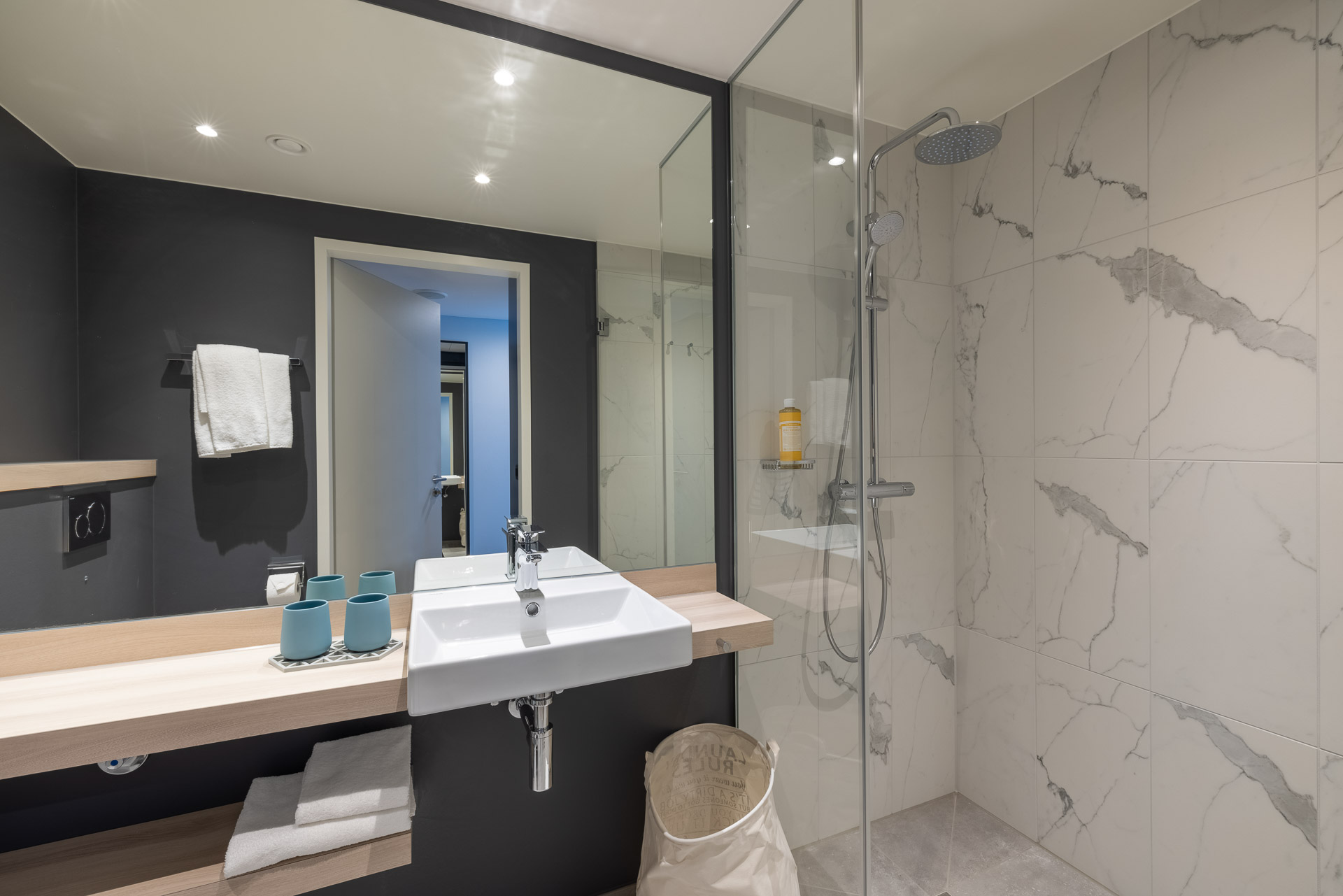 Insight into a modern bathroom with glass shower in the Apartment Basic for temporary living in Zurich